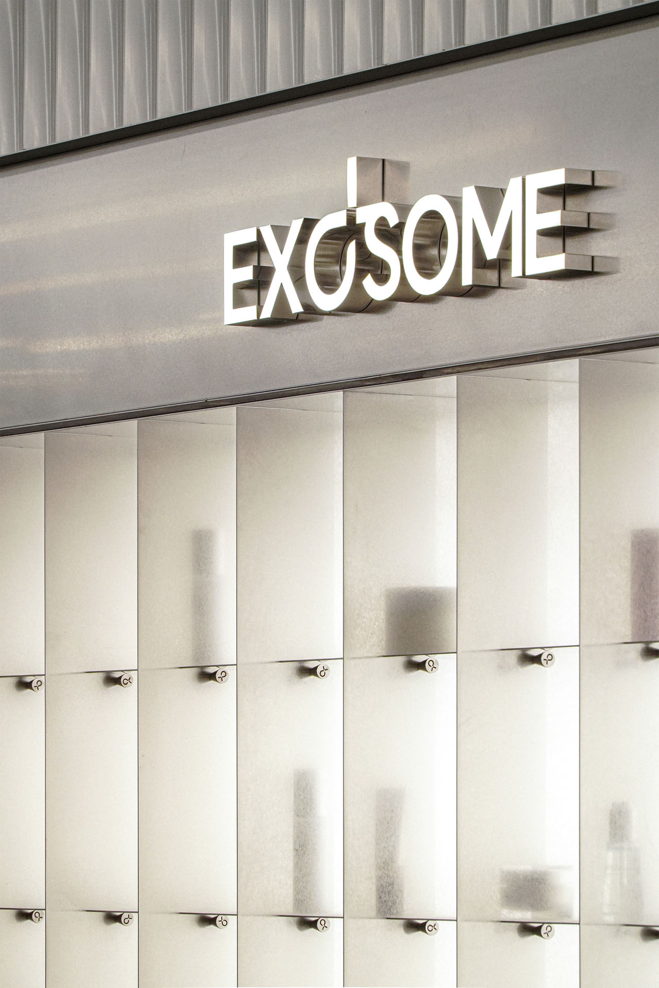 1층 'EXOSOME' 금속 글자와 반투명 진열 벽