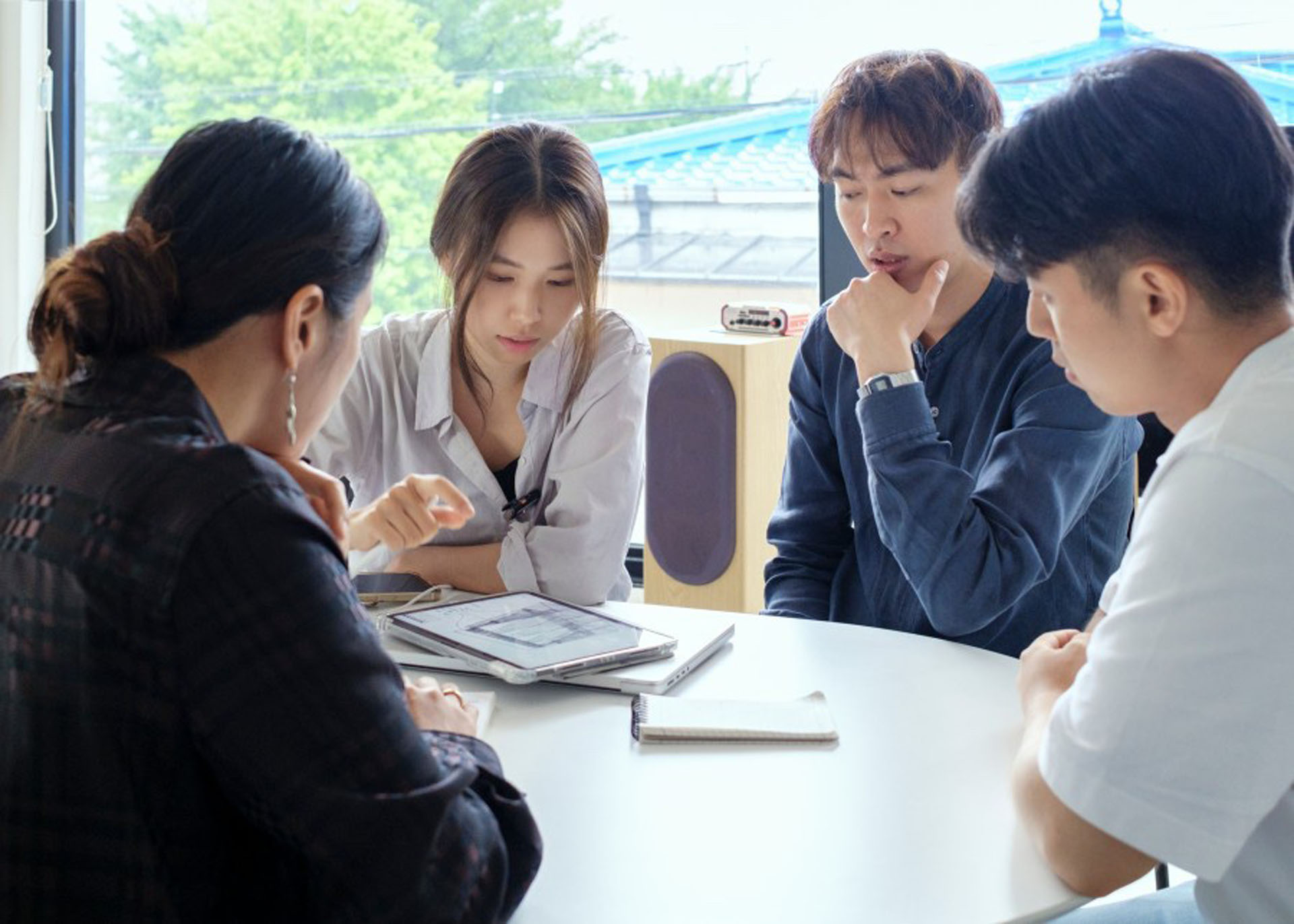 태블릿으로 자료를 함께 보는 네 사람